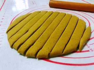 平底锅高钙小馒头,拿出来在案板上揉两分钟排气，用擀面杖擀成厚点的片，不要擀太薄了，用刀把擀好的面片切成宽窄一样的长条。