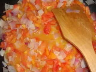 意大利美味——菠菜鸡肉排,黄油化开，放入另一半的洋葱丁炒至半透明，加入西红柿丁炒软，炖烂