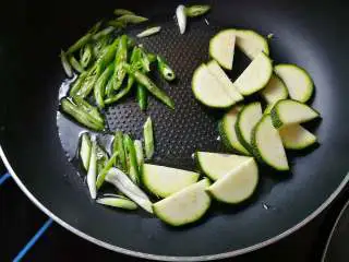 月半弯炒(拌)面,适量食用油7成熟时下葱白段、青椒斜片;因青南瓜片的厚度,需要早早下锅,这样全程会给其他食材浸入丝丝清甜;