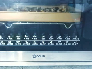 烤箱版【金针菇蒜香烤花蛤】,东菱烤箱提前预热,烤盘放中层,按烤生蚝键,230度烤10分钟即可。