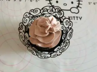 女巫杯子蛋糕,晾凉的蛋糕放到黑色纸托中,上边挤打发的巧克力奶油!最后在奶油上摆上女巫的帽子即可