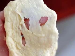 超绵软吐司(一次发酵),面团揉至光滑,可以拉出粗膜的时候放入软化好的黄油,继续高速揉至黄油充分与面团混合。