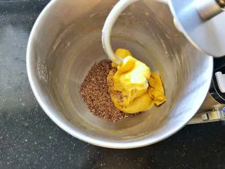 亚麻籽南瓜软欧包,6、倒入熟亚麻籽启动一档揉2分钟,将熟亚麻籽完全均匀的揉入面团中。