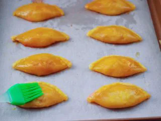 草莓芝士酥～蛋挞皮版,鸡蛋打散搅拌均匀后，把每个草莓芝士酥均匀刷上蛋液。