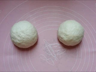 馅料足足的超级至尊匹萨,取出面团,按压排气后分成两个相同大小的面团,滚圆,盖上保鲜膜静置15分钟。