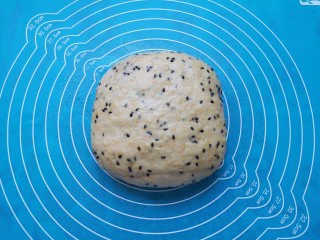 麦片芝麻小餐包,发酵好的面团从面包机里取出,拍打排气。