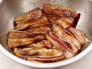 日式柠香烤鳗鱼,把调料汁均匀的涂抹在鳗鱼身上。