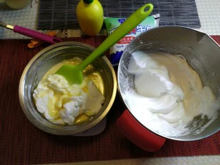 烘焙入门戚风蛋糕,取三分之一的蛋清与蛋黄糊进行翻拌,一定要抄底翻,切记不可以画圈似的搅拌,会使蛋清消泡。