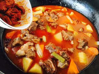 #食二星座# 罐焖牛肉(34图详细步骤),倒入适量的红面酱和适量的开水(牛骨头汤),汤汁的量没过食材,翻炒均匀,大火炖开,小火炖20分钟左右。 在炖红烩汁牛肉土豆期间,把酥皮从冰箱冷冻室里拿出来解冻。