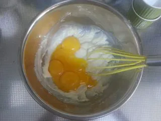 烘焙基础——戚风蛋糕,在搅拌好的面糊中加入蛋黄。