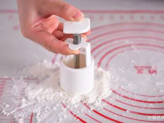 【烘焙配方】经典广式月饼,将50克月饼模具花片装好,按下让花片粘到面粉,再用力磕掉多余的粉