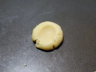 咸香芝士曲奇饼干,用拇指在中心处按压下去，像图片中这样。