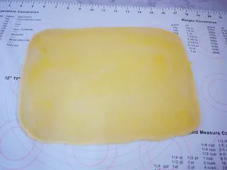 日式炼乳手撕面包,把面团擀成薄片,表面刷一遍炼乳酱,不要全部刷完,留下一点后面刷表面