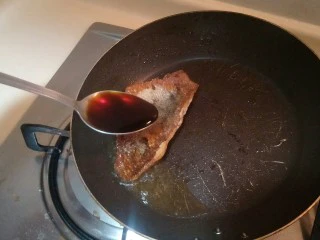 健康低卡香煎鲈鱼,加入一勺生抽调味。