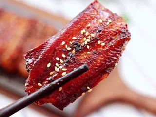 日式柠香烤鳗鱼,取出鳗鱼撒上炒熟的黑、白芝麻即可。