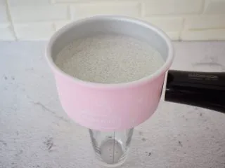 黑芝麻慕斯蛋糕,取出已经凝固的慕斯蛋糕,底部用杯子垫上,再用吹风机对着模具四周吹一吹