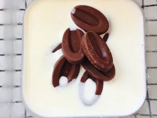 网红脏脏包（开酥版）,将淡奶油加热，趁热将巧克力放入淡奶油中。静置一会儿，搅拌均匀。