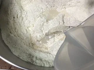 蔓越梅椰蓉扭扭包,启动厨师机搅拌后倒入清水。