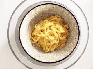 南瓜酱汁牛肉面,把煮好的面条沥干取出，隔冷水备用（把面条盛入小碗中，放在装有冷水的大碗中备用），加几滴植物油，稍加搅拌。 不放冷水中放凉也是可以的，只要后面操作速度相对快一点，不要让手工面变得很黏糊，因为小芽要拍照，速度相对比较慢，所以就隔冷水放了。