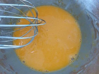 咸蛋黄肉松盒子蛋糕,先把油放进蛋黄内，用手动打蛋器搅拌均匀。再加入纯净水搅拌均匀。