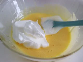 瑞士蛋糕卷之雪融蛋糕,做圣诞应景美食,取约1/3的蛋白霜和蛋黄翻拌混合均匀。