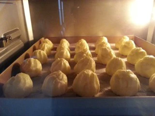 芋泥肉松泡芙,放入预热好的烤箱,中层上下火180度,烤20分钟,再调到160度,烤15分钟