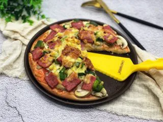 蔬菜火腿披萨,还想拍几张，可是女儿已经等不了了，于是先切了一块给她，她说太好吃了