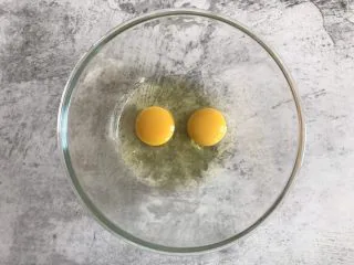 巧克力纸杯蛋糕,两个鸡蛋打入碗中