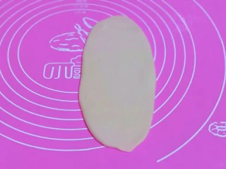 椰香桂花豆沙酥,取一面团，用掌心轻轻按压，再用擀面杖来回擀长舌状。