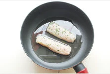 西餐轻松家里做【迷迭香煎鳕鱼】,平底不粘锅加入橄榄油烧热，腌好的黑线鳕鱼肉淋柠檬汁放入油中；