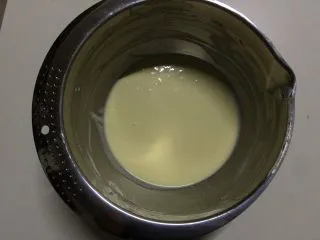 百香果冻芝士蛋糕,14克的吉利丁片提前泡冷水软化,隔水加热融化后冷却至室温,加入到芝士液中,边倒边搅拌均匀