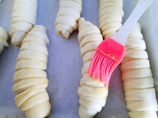 #甜味#毛毛虫豆沙面包,发酵好的面包胚取出全部刷上蛋液。