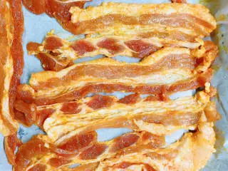 烤五花肉（奥尔良烤翅味）,烤盘铺上油纸，将腌制好的五花肉平铺在上面