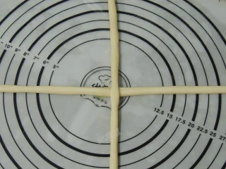 砂糖麻花面包,将面团搓成细长的条状,每两根一组,交叉摆放。