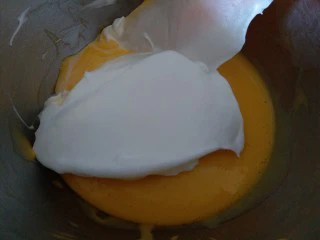 圣诞杯子蛋糕,分三分之一的蛋白霜到蛋黄糊内,用刮到翻拌切拌均匀。