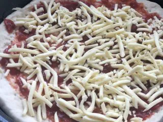 意式烤肠披萨,放入一层芝士。