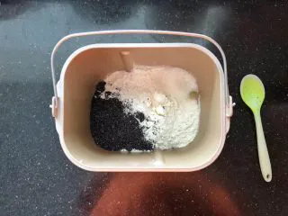 黑芝麻吐司(一次发酵）,把主面团里除黄油和干酵母以外的材料按照先液体后固体的顺序依次放入面包机中。