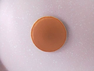 铜锣烧（印花版),翻面，颜色刚刚好，很漂亮，翻过来煎一分钟即可。如果翻过来颜色很浅，那下一个延长一点时间，如果糊了，就缩短时间，这个自己掌控。 然后把锅子放在湿毛巾上，听到“滋滋”的声音，停留两秒，给锅子降降温，然后再烙第二个。