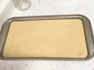 咖啡玉枕蛋糕,吐司盒底铺上烤盘纸，方便脱模，再震几下消泡。