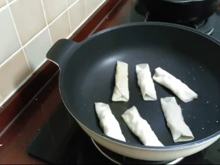 芙蓉鳕鱼锅贴,锅中倒入适量油,小火放入锅贴,慢煎。