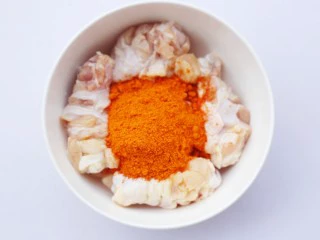 骨头都啃光的奥尔良鸡翅根,参照腌制比例将腌料倒入鸡翅根中。