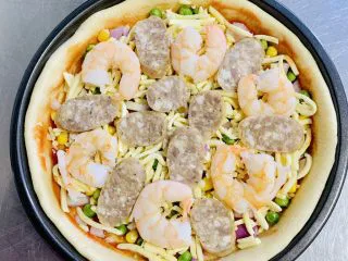 一次发酵——虾仁牛肉肠披萨,均匀摆入虾仁、牛肉肠再放上一层马苏里拉奶酪。
