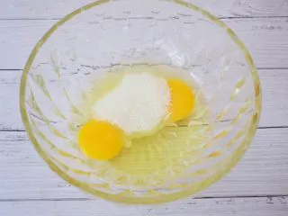 苹果千层蛋糕,鸡蛋打入容器中，加入细砂糖，用手动打蛋器搅拌均匀