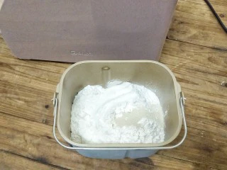 椰蓉奶油面包,把除黄油和盐以外的面包用料一次放入面包桶里,选择和面20分钟,还有八分钟的时候,加入软化的盐和黄油