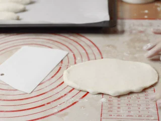 绵绵脆巧奶油包,松弛完毕,擀成长度约18cm的椭圆。