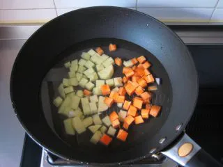 葡国鸡饭：在家复制香浓馥郁的异域美食,煮酱汁： 锅中倒入适量清水，放入胡萝卜和土豆丁煮至八成熟。 