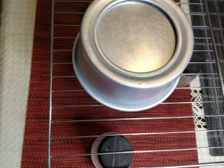 烘焙入门戚风蛋糕,倒扣在凉网上,待至完全凉透以后就可以脱模了。