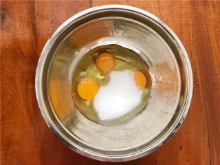 柠檬玛德琳甜甜圈,鸡蛋和白砂糖放到容器里。