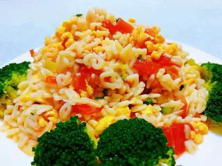 番茄鸡蛋拌意面,鲜美可口的番茄鸡蛋拌意面装入盘中摆上西兰花做装饰