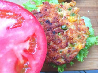 鸡肉蔬菜饼汉堡,放上煎好的鸡肉饼,在放上番茄片